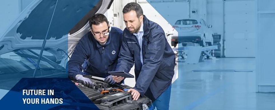 2 Mitarbeitende betrachten über eine geöffnete Motorhaube gelehnt die Daten auf einem Tablet. Darunter der Slogan Future in your hands.