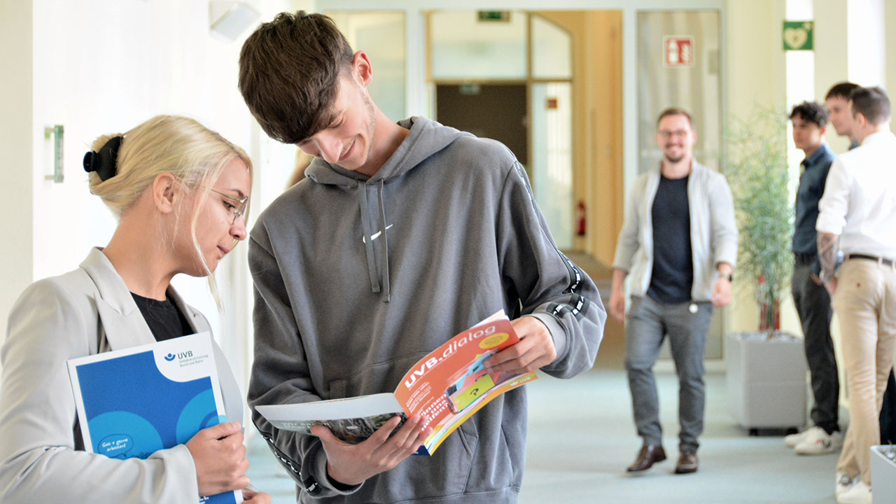 Junge Menschen schauen sich Prospekt an