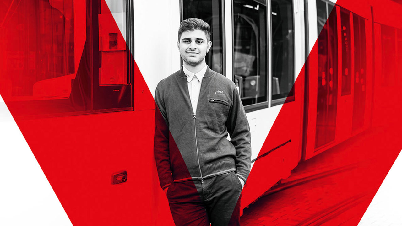 Schwarzweißbild einer jungen Person, die sich an einen Bus anlehnt, über das Bild ist im Vordergrund ein rotes V gelegt