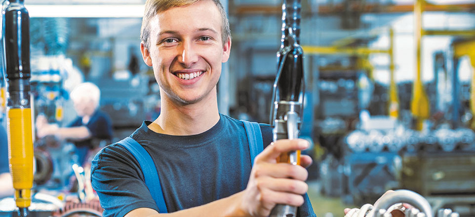 Junger Mann in der Werkstatt mit einem technischen Gerät