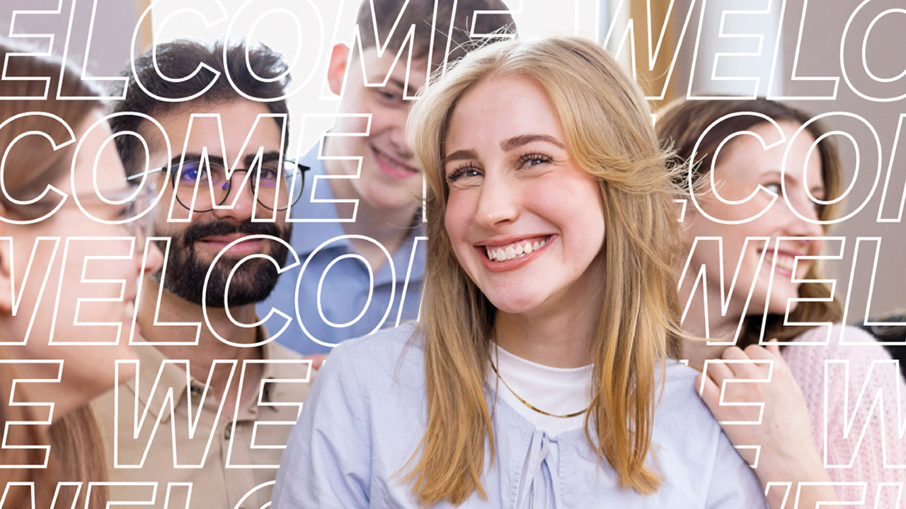 Das Bild zeigt mehere Personen, wobei nur eine von ihnen klar zu sehen ist. Über die restlichen Personen läuft ein Schriftzug "WELCOME".