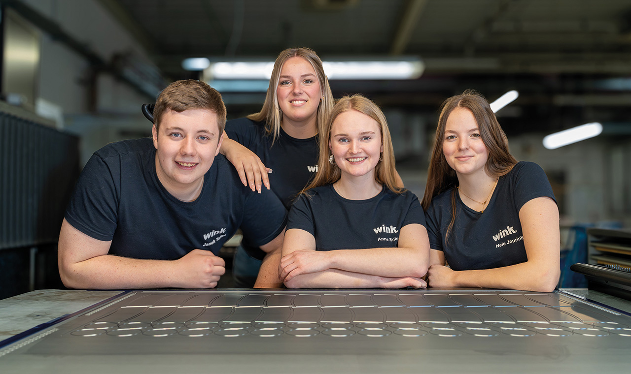 4 Azubis von WINK die in die Kamera lächeln