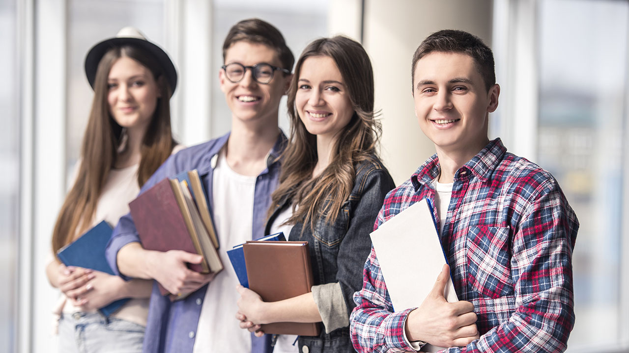 Gruppe junger Menschen mit Büchern im Arm