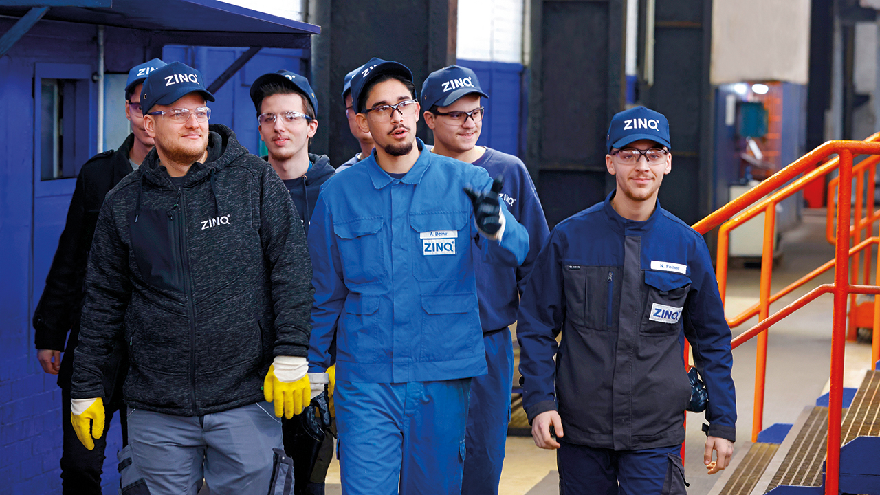 Gruppe von 6 Mitarbeitern von ZINQ in Arbeitskleidung