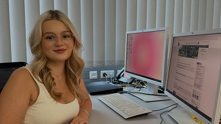 Josephine Post an ihrem Schreibtisch sitzend.