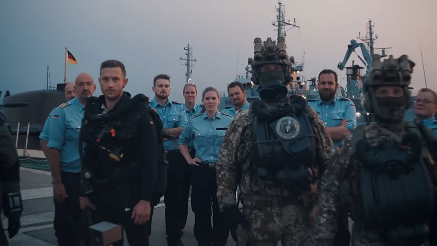 Soldaten und Soldatinnen der Bundeswehr vor Schiffen im Hafen.