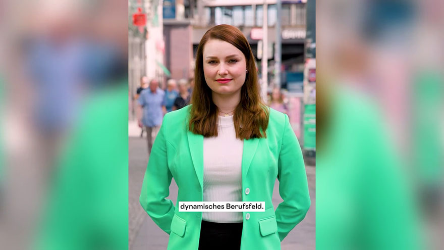 Junge Frau (Rechtsanwalts- und Notarfachangestellte) vor Menschen in der Innenstadt.