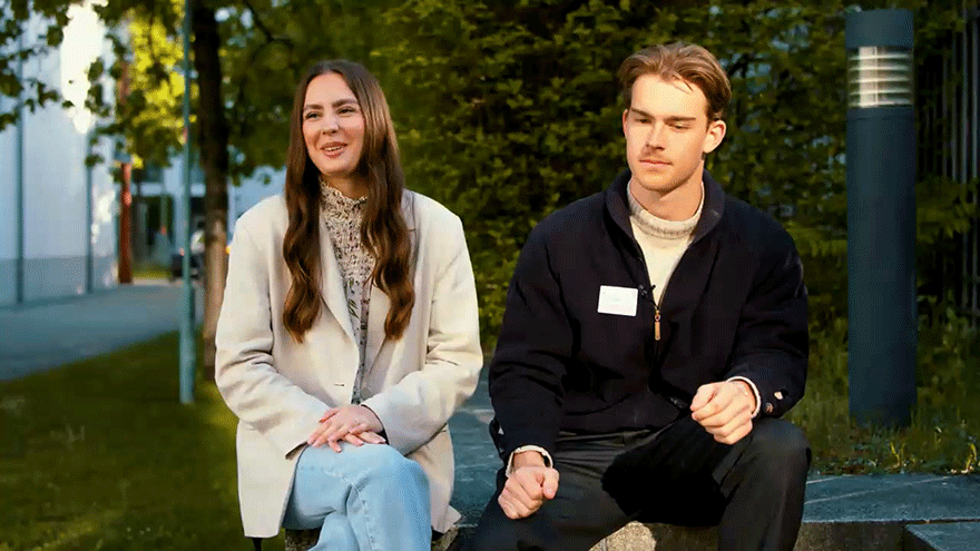 Studierende auf einer Bank sitzend.