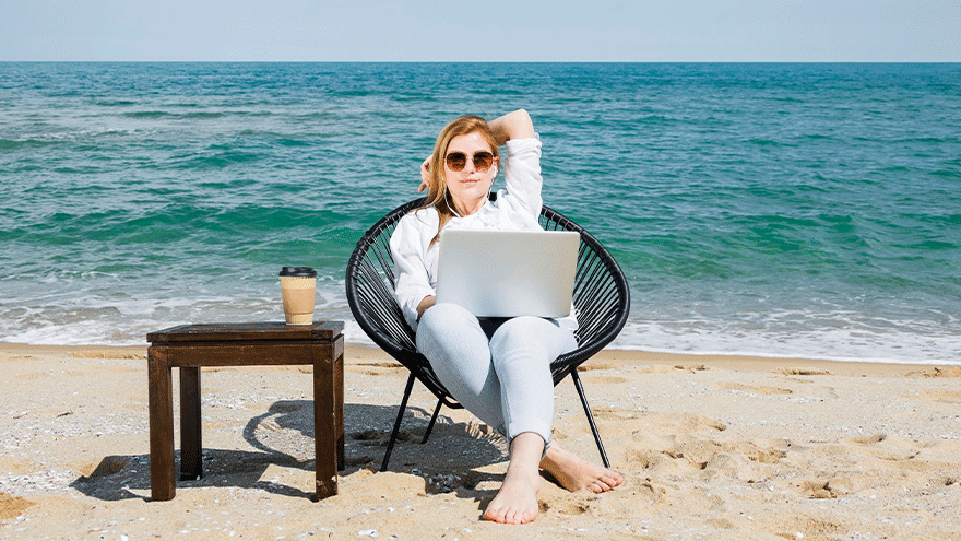 Frau arbeitet mit Laptop am Strand (Symboldbild). Bild von Freepik.