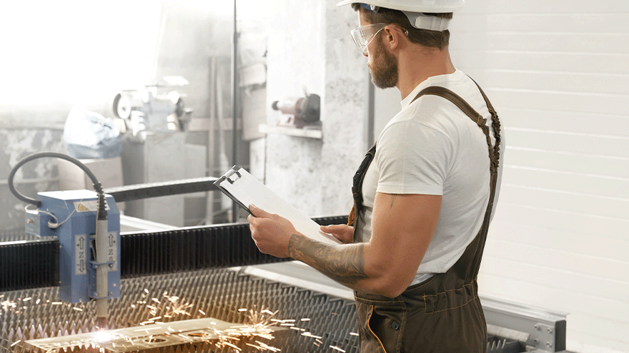 Metallbauer an einem CNC-gesteuerten Plasmaschneider (Symbolbild). ©serhii_bobyk auf Freepik.